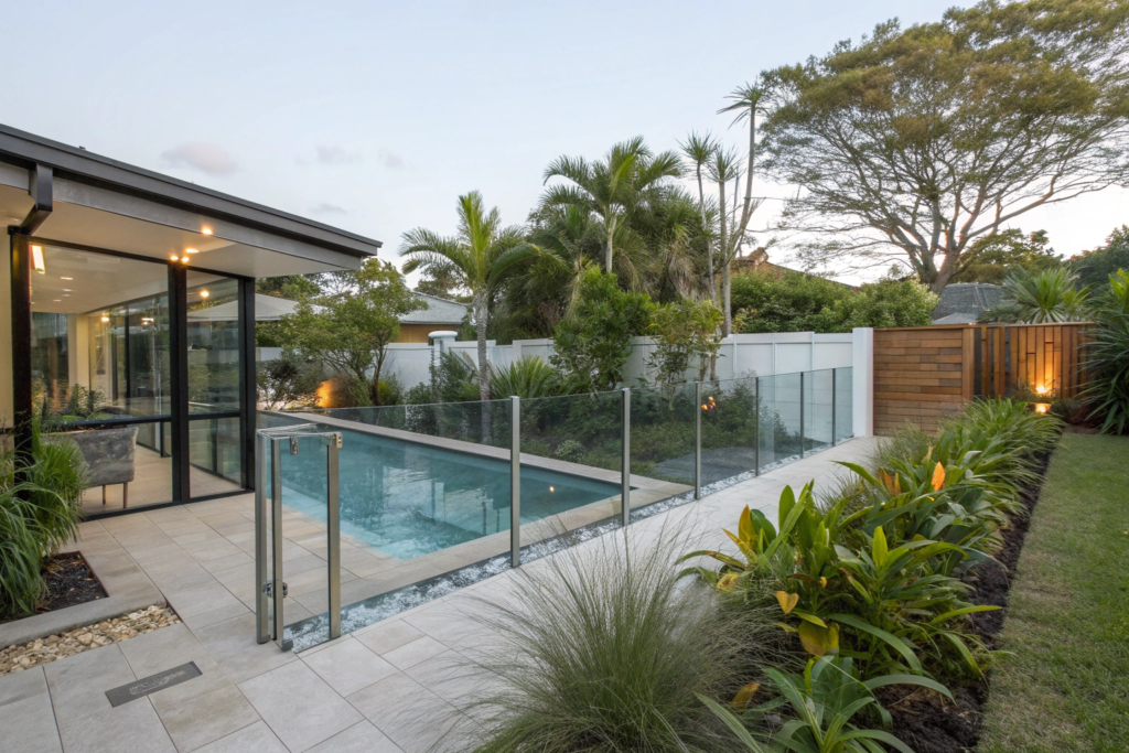 backyard pool area with frameless glass pool fenci